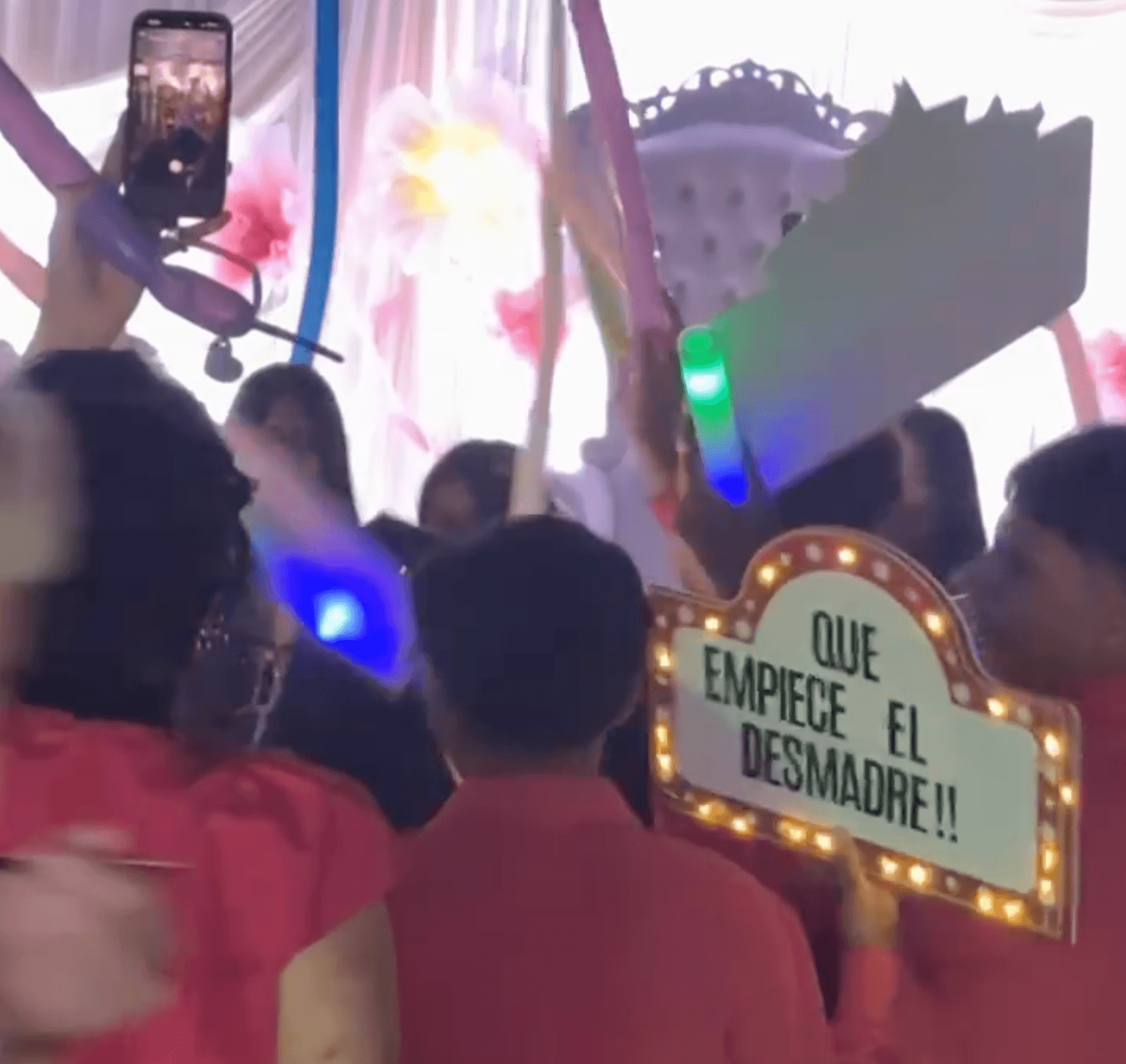 Guests celebrating with glowing party props and a festive Spanish-language sign.
